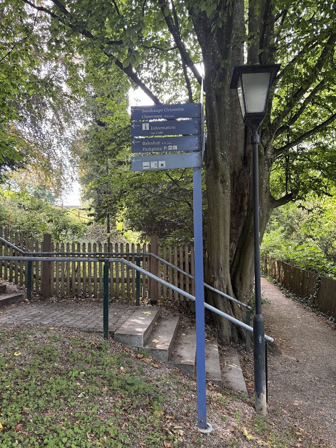 Wegweiser Richtung Ortsmitte und Osterseen im Park von Seeshaupt